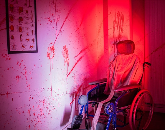 http://Un%20fauteuil%20roulant%20est%20tourné%20vers%20un%20mur%20éclaboussé%20de%20sang.%20Sur%20le%20mur%20se%20trouve%20un%20cadre%20avec%20une%20image%20qui%20montre%20l'anatomie%20du%20corps%20humain.